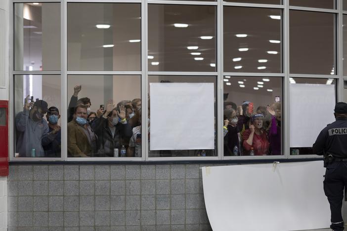 A crowd chants "Stop the count!" and pounds on the windows and doors after partisan election challengers were told that the capacity for election challengers had been met in the counting facility at what was then Detroit's TCF Center on Nov. 4, 2020.