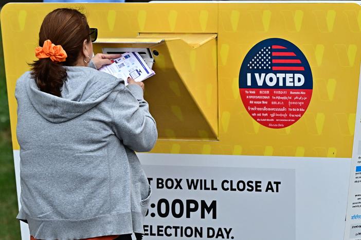 A voter puts their ballot in a drop box in Norwalk, Calif., during early voting in Los Angeles County. People who vote in the 2024 general election can track their ballots as they move through the system.