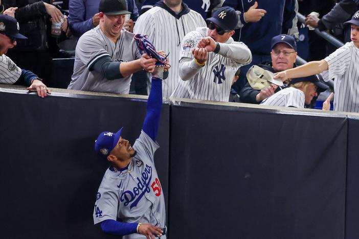 Fans interfere with Mookie Betts of the Los Angeles Dodgers as he attempts to catch a fly ball in foul territory during Game Four of the 2024 World Series against the New York Yankees at Yankee Stadium on Tuesday.