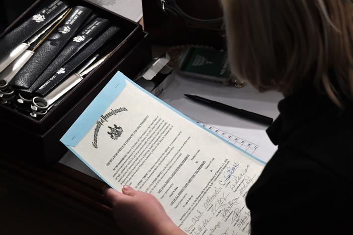 A person holds the certificate of electoral votes from Pennsylvania during a joint session of Congress early on Jan. 7, 2021, as the counting of electoral votes resumed after the riot at the U.S. Capitol.