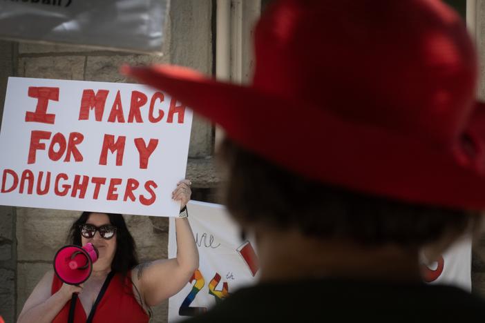 People gather at a women's rights march in Chicago on the second anniversary of the <em>Dobbs</em> decision, the Supreme Court ruling that overturned <em>Roe v. Wade</em> and struck down federal abortion protections.