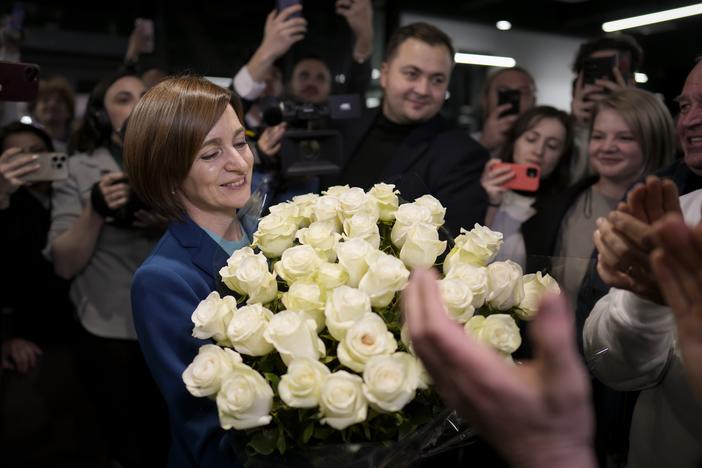 Moldova's President Maia Sandu smiles while holding a bouquet of flowers as she celebrates with supporters the preliminary results of the presidential election runoff, in Chisinau, Moldova, Sunday, Nov. 3, 2024.