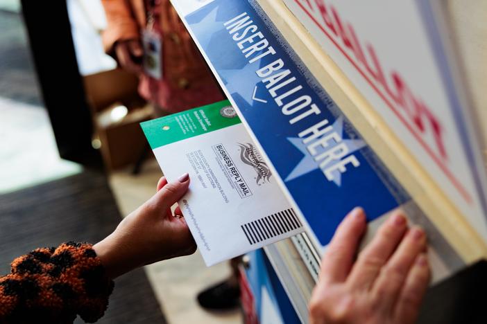 A person drops off a mail-in ballot on Oct. 15 in Doylestown, Pennsylvania. An unknown number of women are hiding their choice of Vice President Harris from family and partners in an election that is projected to have a historic gender gap.