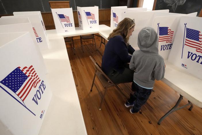 Aliza Bidinger is accompanied by her son Jayce, age 6, as she votes at the 146-year-old Buck Creek school on Election Day, Tuesday, Nov. 5, 2024, in rural Perry, Kan.