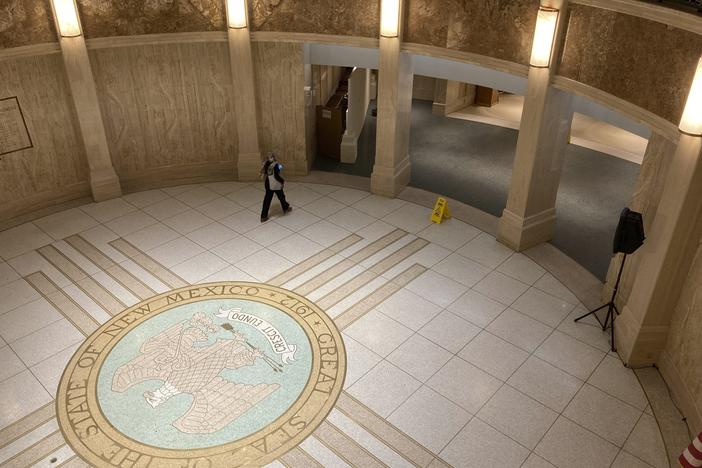 A pedestrian traverses the rotunda in the New Mexico state Capitol building in Santa Fe, N.M.