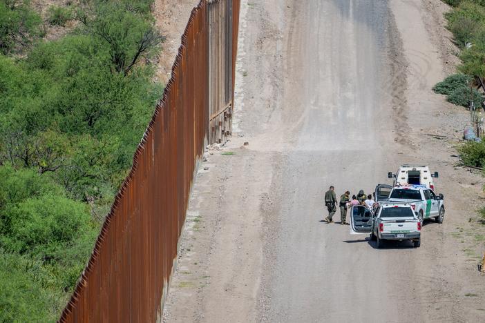A group of migrants are apprehended by U.S. Customs and Border protection officers after crossing over into the U.S. on June 26, 2024 in Ruby, Arizona.