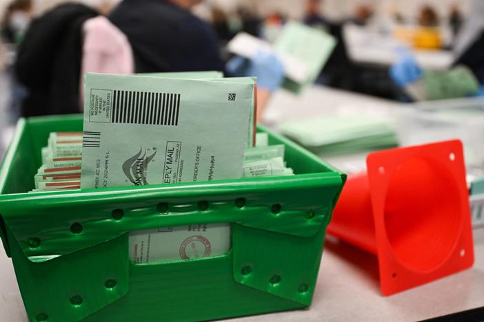 The USPS Election Mail logo is displayed as ballots sit in a tray inside the Maricopa County Tabulation and Election Center (MCTEC) on Election Day, Nov. 5, in Phoenix, Arizona.