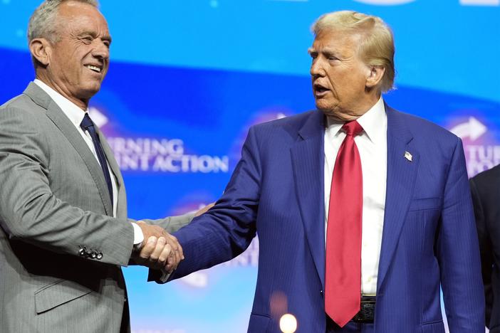 President-elect Donald Trump shakes hands with Robert F. Kennedy Jr., at a campaign rally in October. Kennedy, who is skeptical of vaccines, is among Trump's advisors on health.