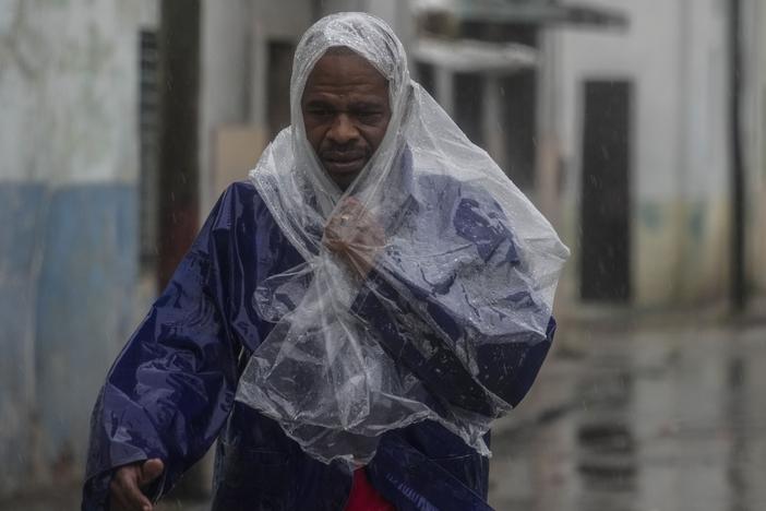 A man walks through the wind and rain brought by Hurricane Rafael in Havana, Cuba, Wednesday, Nov. 6, 2024.