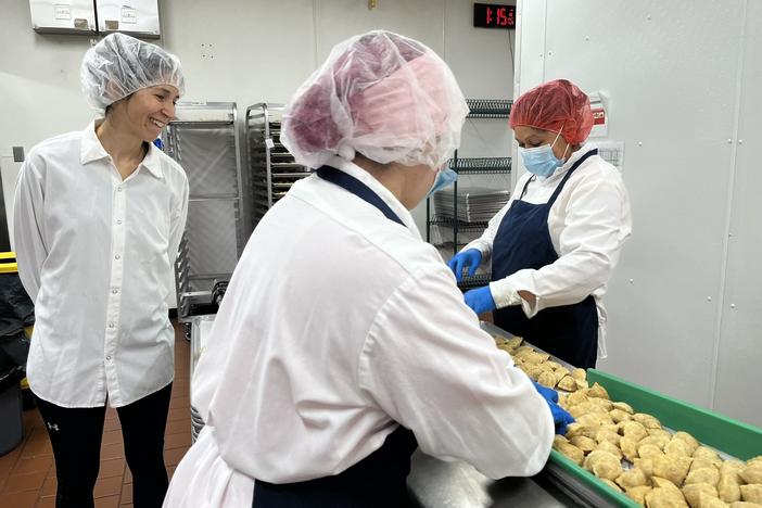 Margarita Womack, owner of the frozen empanadas company MasPanadas, (left,) looks over staffers inspecting empanadas to ensure quality control. Imperfect empanadas such as those with an uneven shape are removed and donated.
