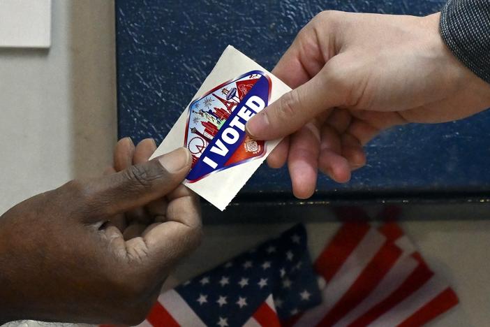 A voter receives a Las Vegas-themed "I Voted" sticker after casting their ballot inside the Galleria at Sunset mall on November 05, 2024 in Las Vegas, Nevada.