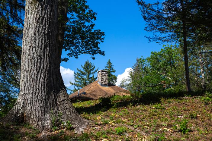 An iconic Carpathian-style roof and stone chimney peek out of the woods in the heart of Soyuzivka’s campus.