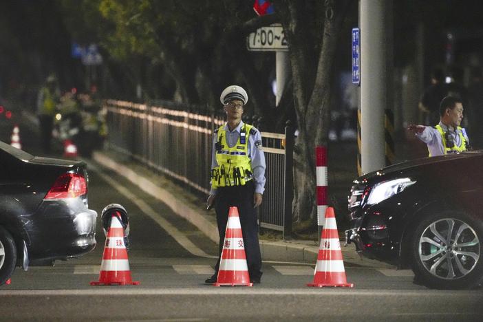 A security person stands guard near a sports center where a man rammed a car into people exercising in Zhuhai, China, on Monday.