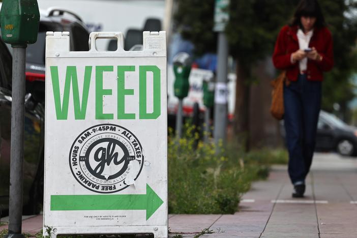 A "weed" sign advertises a cannabis dispensary in Los Angeles. With a new Trump administration coming into the White House, marijuana could remain on a path toward relaxed federal restrictions.