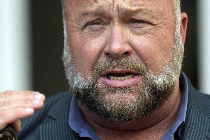 Right-wing conspiracy theorist Alex Jones speaks outside the federal courthouse after a June bankruptcy hearing in Houston.