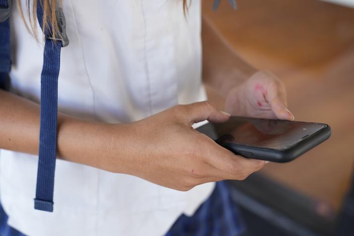 A teenage girl uses her phone to access social media in Sydney, Friday, Nov. 8, 2024.