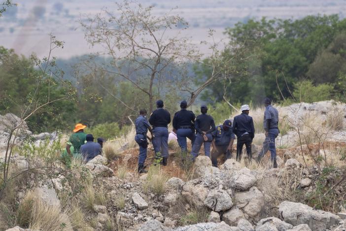 Rescue workers, left, remove a body from a reformed mineshaft where illegal miners are inside in Stilfontein, South Africa on Thursday.