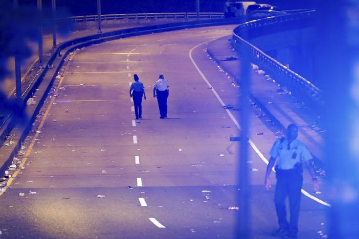 New Orleans police walk up the Almonaster Avenue bridge after a deadly shooting in New Orleans, Sunday, Nov. 17, 2024.