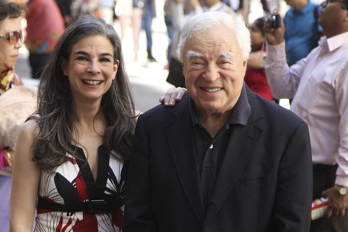 Arthur Frommer, 83, and his daughter, Pauline Frommer, 46, are shown posing among tourists in the Wall Street area in New York, May 20, 2012.