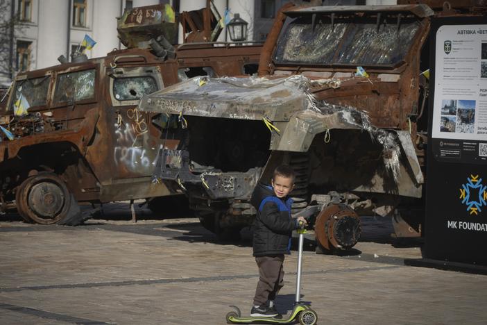 A boy rides a scooter past a display of destroyed Russian military vehicles in Mykhailivska square in central Kyiv, Ukraine on Tuesday, Oct. 22, 2024.