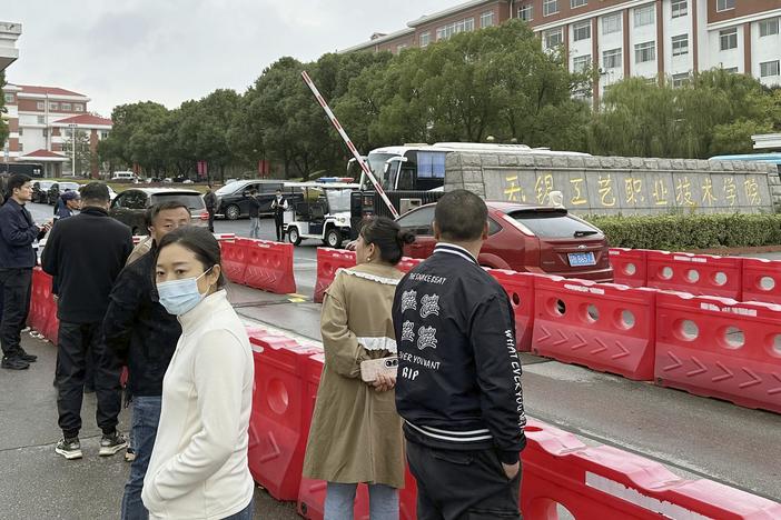 Guardians gather in front of the Wuxi Vocational Institute of Arts and Technology in Yixing, eastern Chinese city of Wuxi on Nov. 17, 2024, a day after a stabbing attack took place.