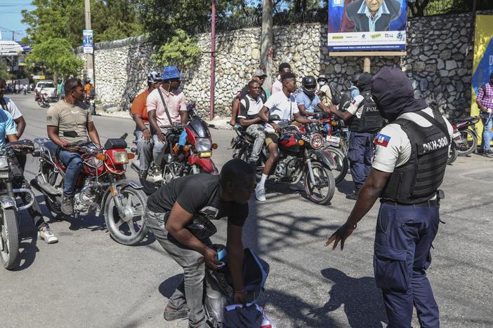 Police officers man a checkpoint checking for weapons, in the Petionville area of Port-au-Prince on Tuesday.