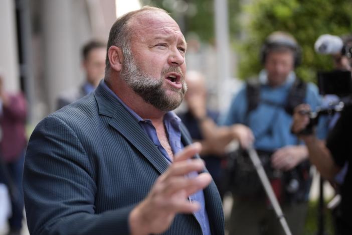 Right-wing conspiracy theorist Alex Jones speaks to the media after arriving at the federal courthouse in Houston for a bankruptcy hearing in June.