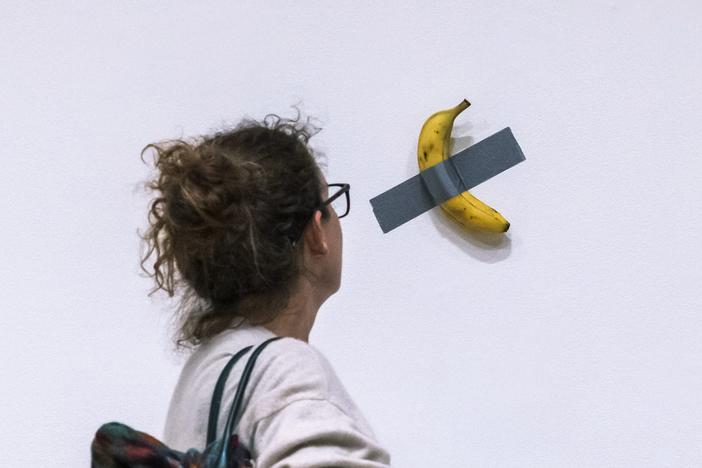 A woman looks at artist Maurizio Cattelan's piece of art <em>Comedian</em> during an auction preview at Sotheby's in New York on Nov. 11, 2024.