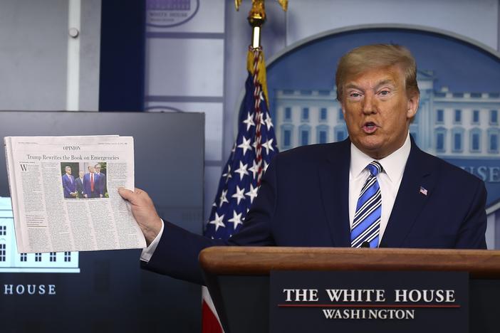Then-President Donald Trump holds up <em>The Wall Street Journal </em>as he speaks at the White House on April 19, 2020.