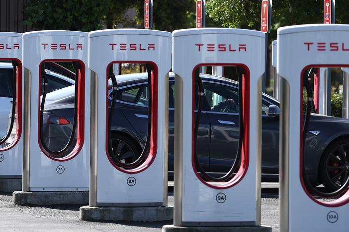 A Tesla charges at a Tesla Supercharger in Petaluma, Calif., in May. Tesla's Supercharger network has more than 30,000 fast-charging ports — more than half of all the EV fast chargers available in the United States. Until recently, they were only open to Tesla drivers, but that's changing.