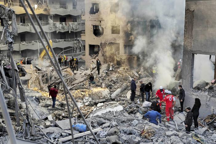 Rescue workers and people search for victims at the site of an Israeli airstrike in Beirut, Lebanon, on Saturday.