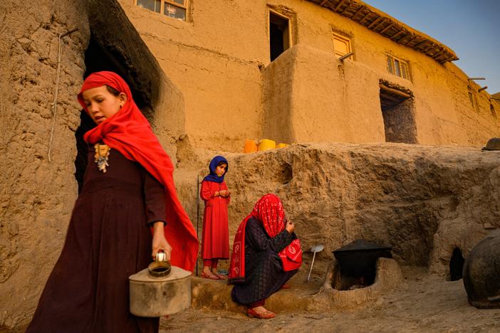 Family members gather by a stove in Afghanistan, which has been hit by droughts over the past three years. The country is ranked one of the most vulnerable and ill-prepared nations in coping with climate change. Global support for projects to address climate-related issues has been largely on hold since the Taliban took power.