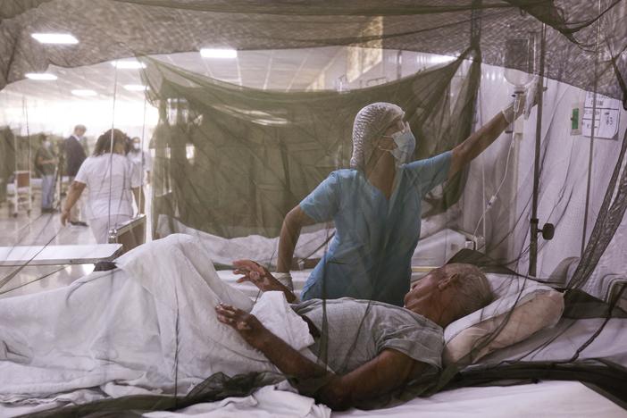 A nurse takes care of a patient at a hospital near Lima, Peru. The country experienced an outbreak of dengue fever in 2024 — a pattern that was replicated in many countries around the world. A new study suggests climate change may be contributing to the spread of the mosquito-borne disease.