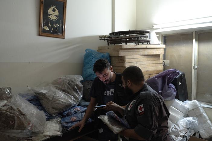 Jad Deeb, a volunteer of the Lebanese Popular Relief Association, prepares school clothes for displaced Lebanese children with one of his colleagues in their office in Beirut, Lebanon.