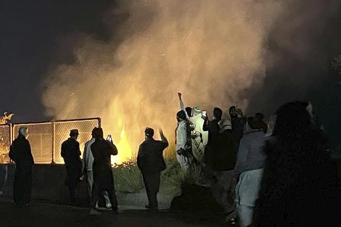 Supporters of imprisoned former premier Imran Khan's Pakistan Tehreek-e-Insaf party, burn bushes to reduce the impact of tear gas shells fired by police officers to disperse them during a rally demanding Khan's release, at a motorway in Ghazi in Attock district, Pakistan on Sunday.