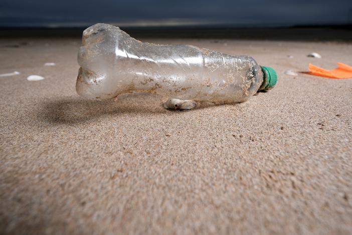 A plastic bottle and the remains of a child's spade on the beach in Prestatyn, U.K..