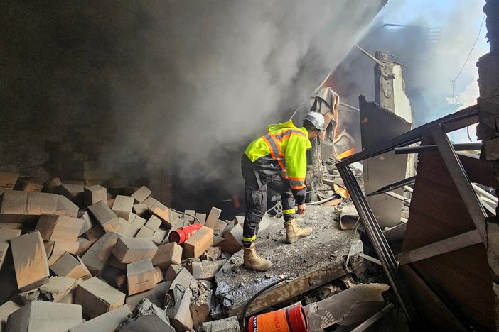 A first responder looks for survivors at the scene of an Israeli airstrike that targeted a building in a southern suburb of Beirut on Tuesday.