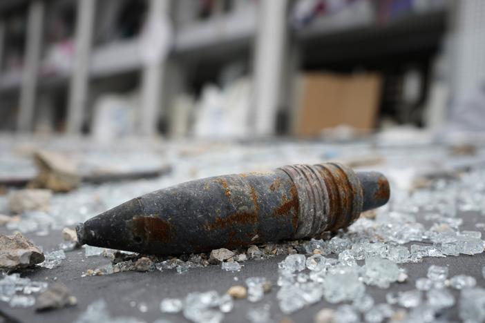 A part of an unexploded bomb lies on the street in front of a destroyed shopping center, following a ceasefire between Israel and Hezbollah that went into effect on Wednesday, in Tyre in southern Lebanon.