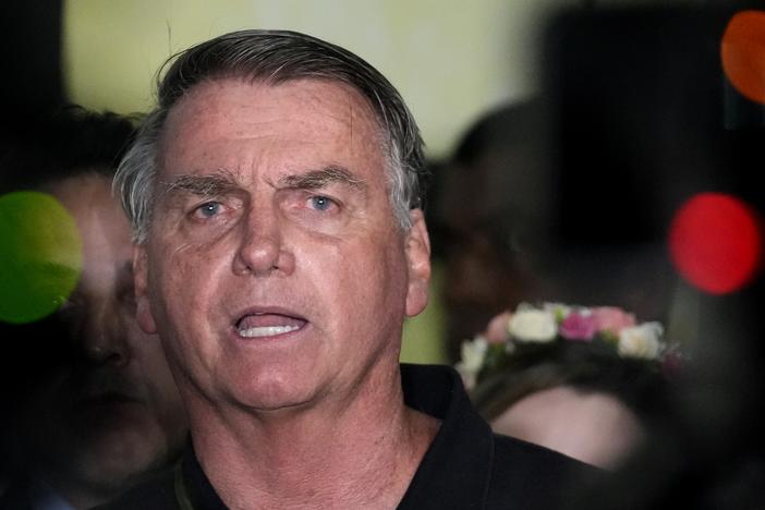 Former President Jair Bolsonaro speaks to the press after being formally charged by the federal police with attempted coup, at the airport in Brasilia, Brazil on Monday.