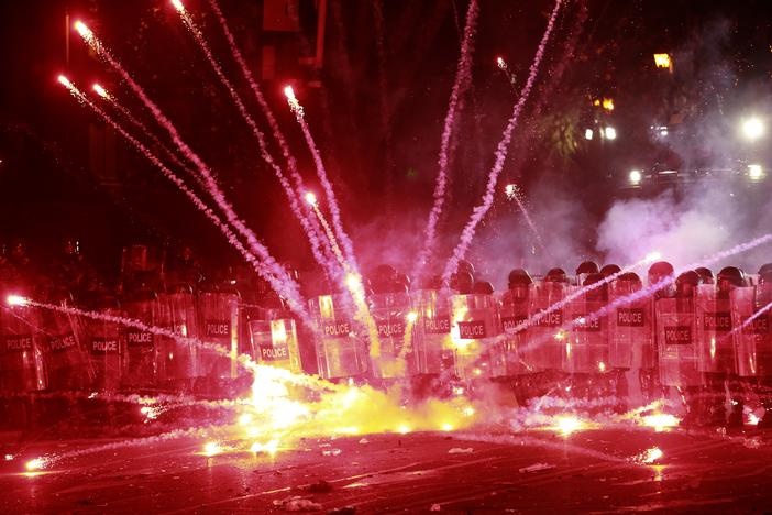 Demonstrators use firecrackers against police during a rally against the government's decision to suspend negotiations on joining the European Union for four years, outside the parliament's building in Tbilisi, Georgia, early Sunday, Dec. 1, 2024.