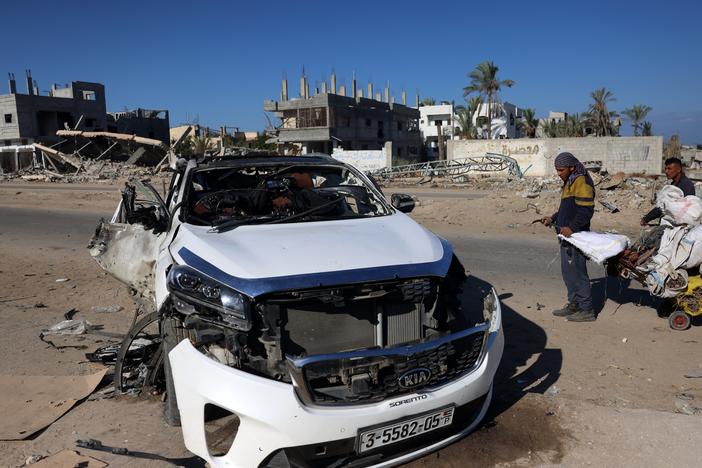 People check a car hit by an Israeli strike in Khan Yunis in the southern Gaza Strip on Saturday. Five people were reported killed, including three World Central Kitchen workers, Gaza's health ministry said.