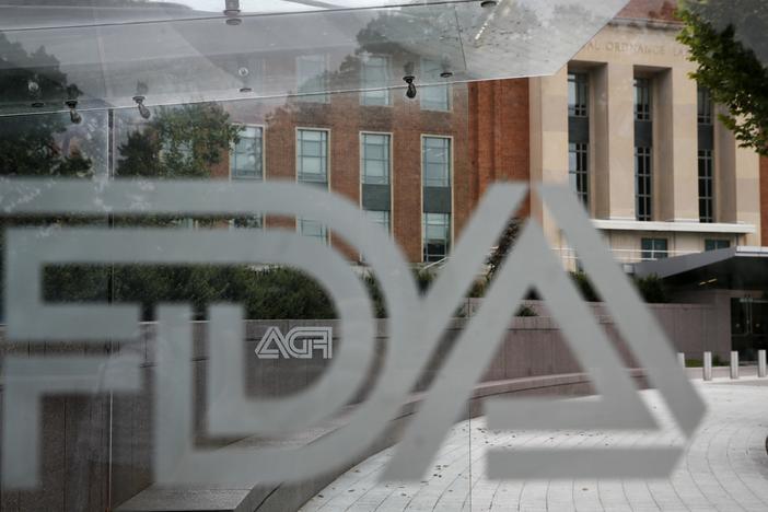 A U.S. Food and Drug Administration building is seen behind FDA logos at a bus stop on the agency's campus in Silver Spring, Md., in 2018. Cucumbers shipped to the U.S. and Canada, and organic eggs sold in 25 Costco stores in five southern U.S. states, were recalled this week for potential salmonella contamination.