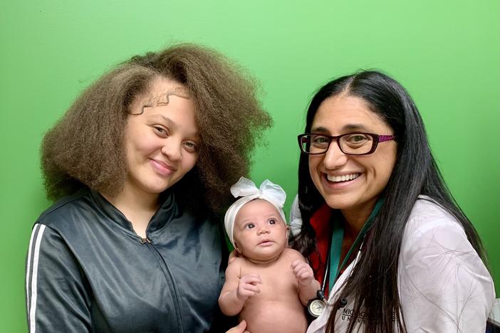 Sh'Amir Spencer and daughter Amira pose with Rx Kids co-director Mona Hanna at the Hurley Children's Center clinic in Flint, Mich. Spencer and her daughter are part of the first cohort of moms and babies in the program, which launched in the city in January.