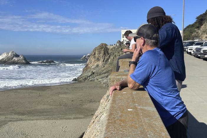 People watch the waves come in at Ocean Beach in San Francisco after an earthquake was felt widely across Northern California on Thursday.