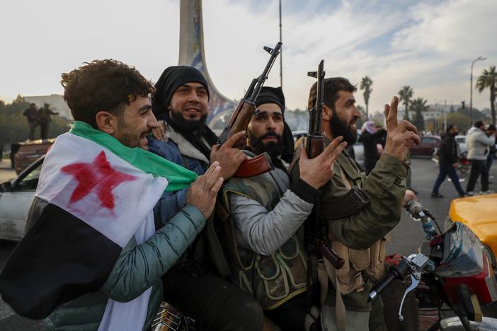 Syrian opposition fighters celebrate after the Syrian government collapsed in Damascus, Syria, Sunday, Dec. 8, 2024.
