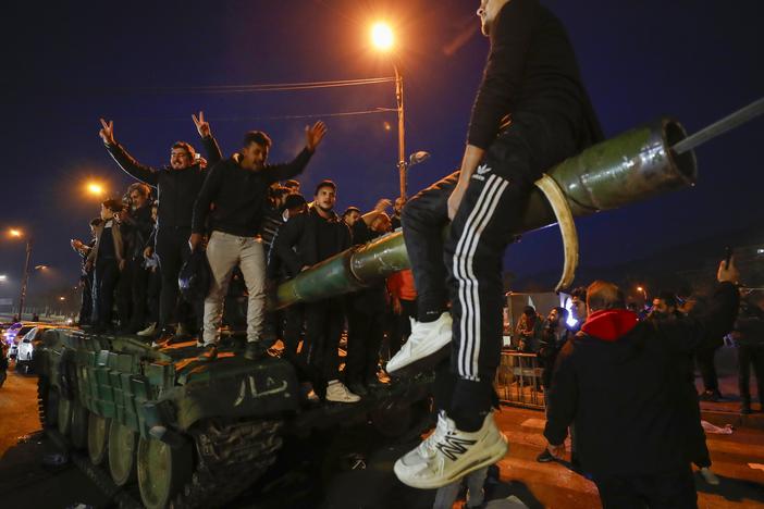 Syrians celebrate the arrival of opposition fighters in Damascus, Syria, on Sunday.