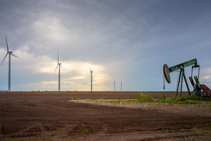 An oil pumpjack is seen near a field of wind turbines in October 2023 in Nolan, Texas. The U.S. oil industry is headed towards a record-breaking year; renewable energy has also set several records this year. Prominent Republicans, including several in President-elect Donald Trump's circle, are talking about an "all-of-the-above" approach to energy that supports fossil fuel and clean energy.