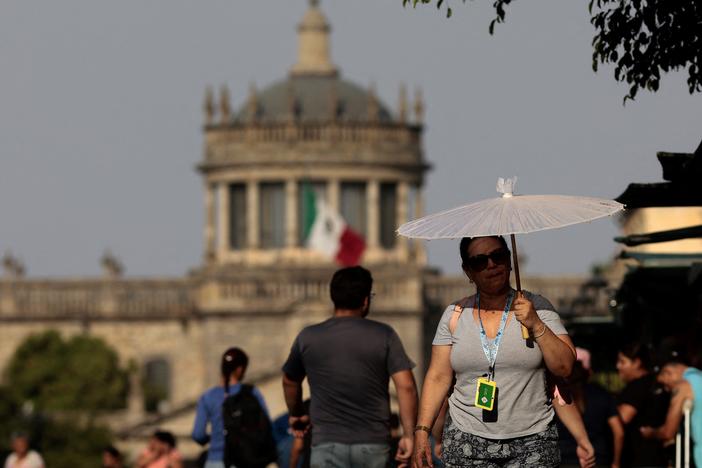 People protect themselves from the sun during a heat wave in Guadalajara, Mexico, in 2024. Temperatures topped 110 degrees Fahrenheit across many parts of the country during the heat wave. A new study finds that young people are disproportionately at risk from extreme heat in the country.