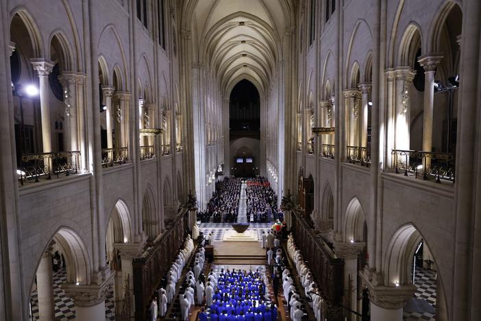 The choir, clergy and guests stand as they sing during a ceremony to mark the reopening of the landmark Notre Dame Cathedral, in central Paris, on Saturday.