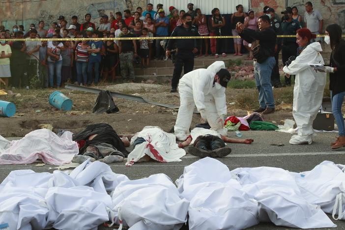 Bodies in bodybags are placed on the side of the road after a deadly semi-trailer truck crash in Tuxtla Gutierrez, Chiapas state, Mexico, Dec. 9, 2021.